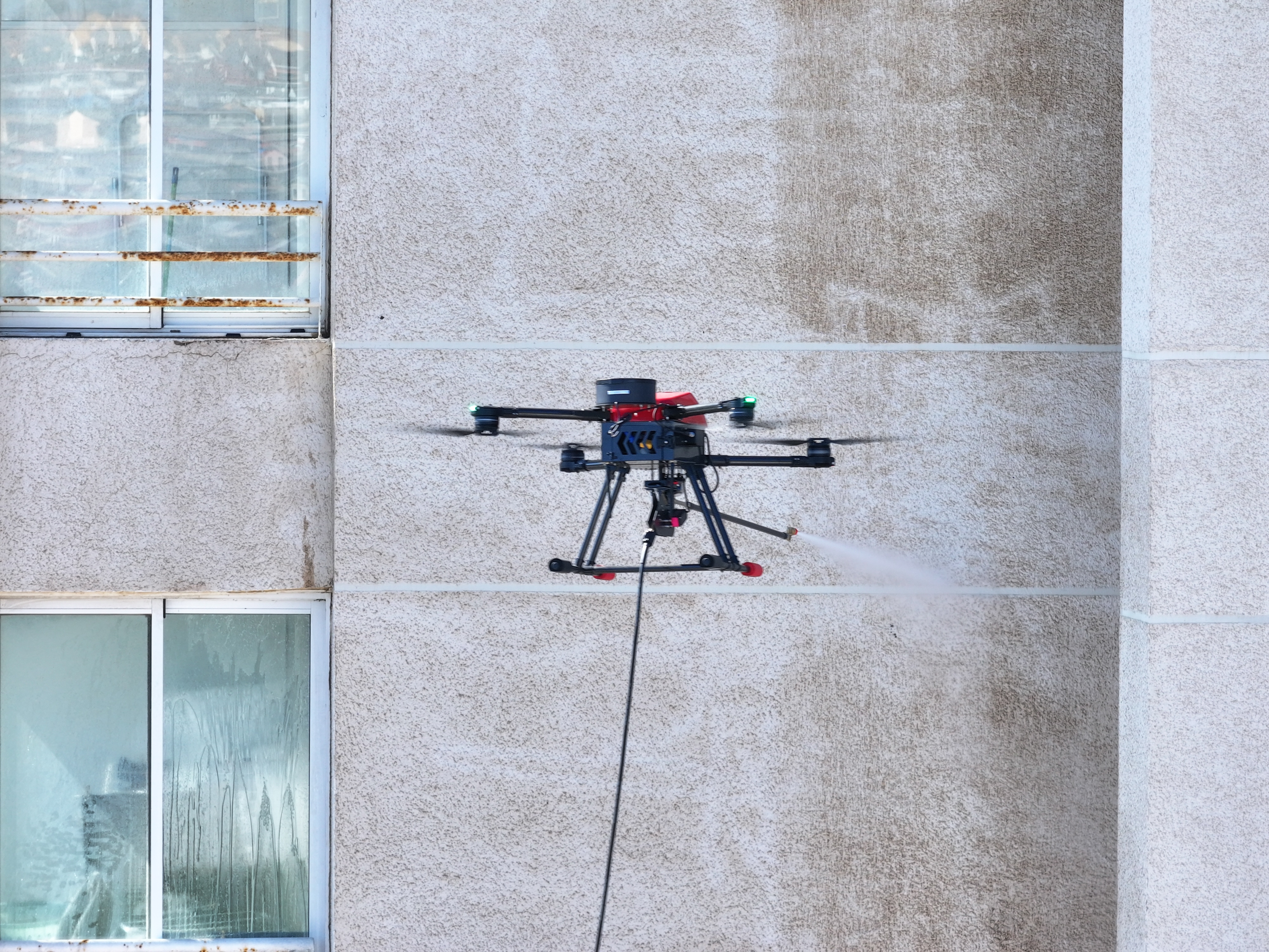 Drone Dronwind limpiando fachada de edificio